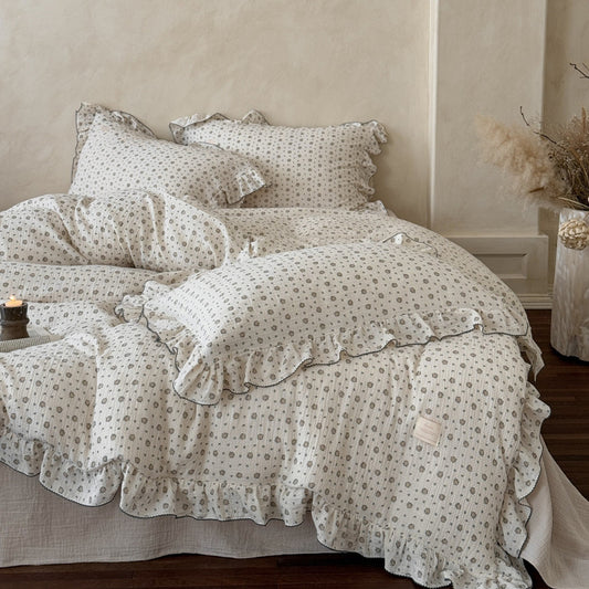 A bedroom decorated with a cotton muslin duvet cover set, featuring a vintage floral print and beautiful ruffle detailing.