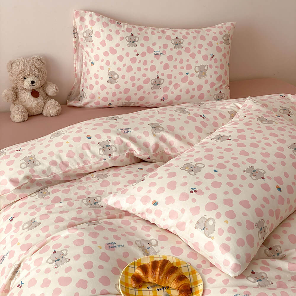 Close-up of pink elephant kids bedding set with matching pillowcases, cute animal pattern, and soft blush sheet
