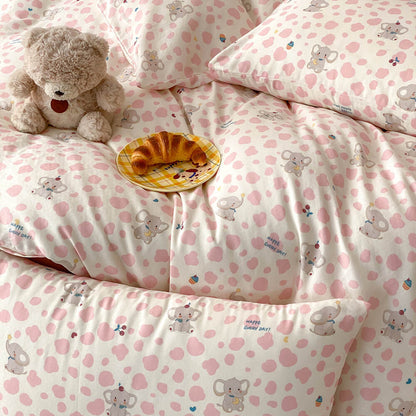 Soft cotton muslin kids bedding with pink elephant pattern, scattered pink spots, and cozy bed styling