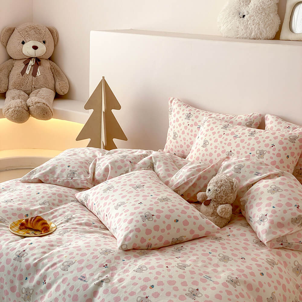 Full view of pink elephant kids bedding set with matching pillowcases, blush sheet, and cozy cotton muslin texture