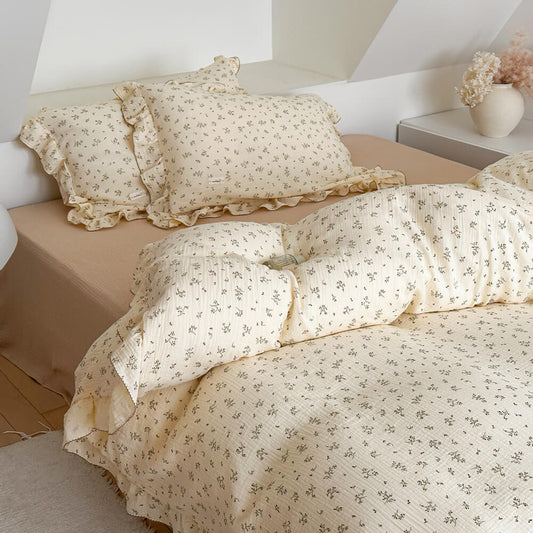 Sand-colored flat sheet paired with olive green floral cotton muslin duvet cover