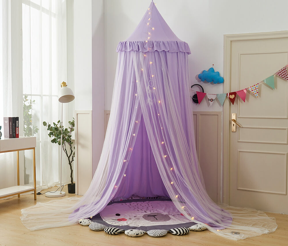 Full-view of a purple double-layer kids bed canopy set up as a play tent on the floor, surrounded by decor for a cozy nook.