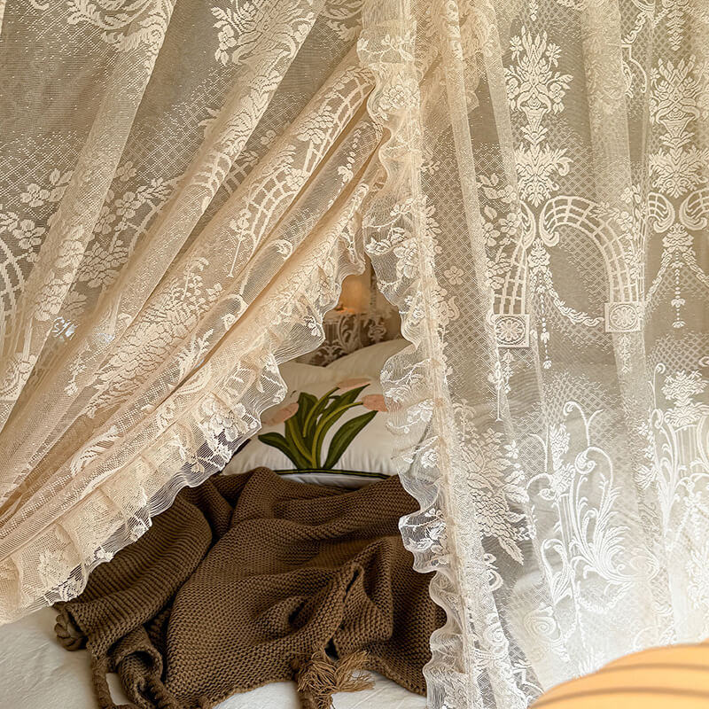 Decorative lace curtains with a cozy interior visible through them.
