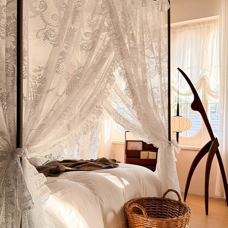Bedroom with canopy bed, lace curtains, and wooden nightstand.