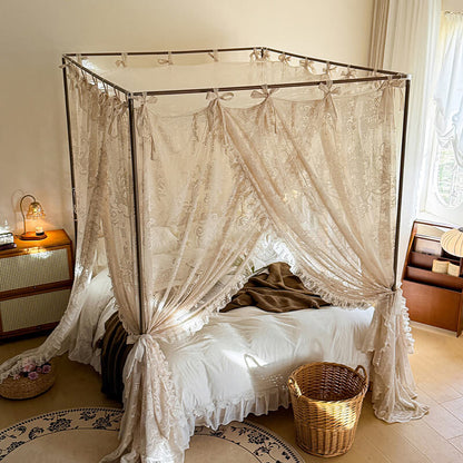 Four-poster bed with lace curtains in a bedroom setting