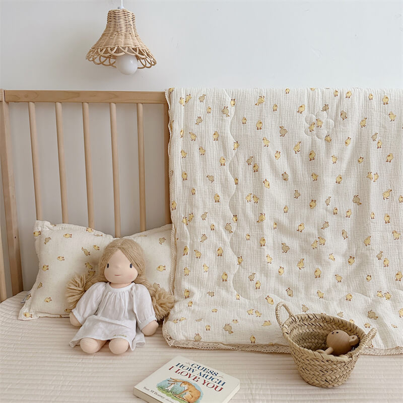 Nursery with wooden crib, floral-patterned blanket, doll, and book.