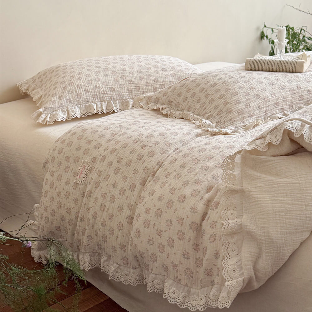 Low angle view of a cozy romantic bedroom setup highlighting the breathable crinkled cotton gauze texture of the dusty pink floral bedding set with scallop lace ruffles.