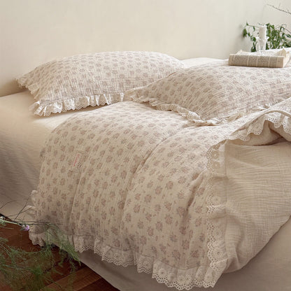 Low angle view of a cozy romantic bedroom setup highlighting the breathable crinkled cotton gauze texture of the dusty pink floral bedding set with scallop lace ruffles.