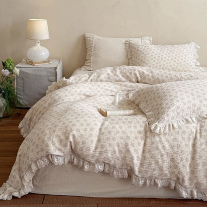 Full view of a warm lit aesthetic bedroom featuring the dusty pink floral bedding set, layered with a solid cream flat sheet, an open book, and fresh green plants.