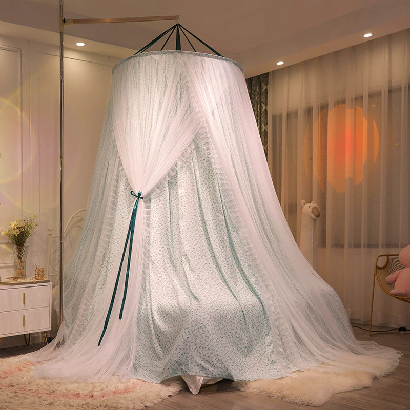 Floor-length bed canopy in teal floral fabric and sheer white netting, completely draped and closed around a full-size bed, creating a private, dreamy space.