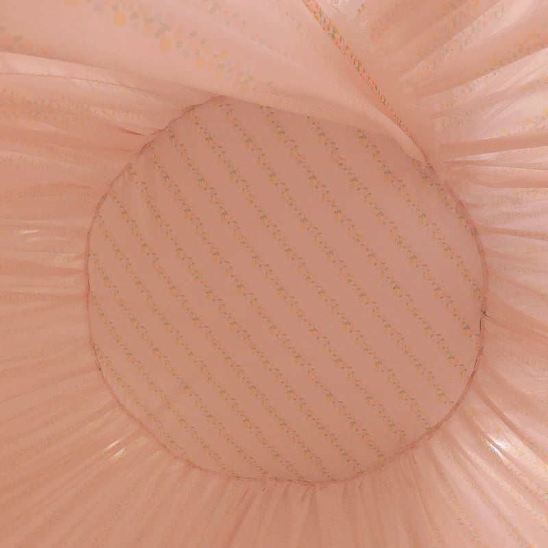 Close-up view of the interior ceiling of the pink fabric bed canopy, showing the soft, light pink floral or striped pattern of the inner liner.