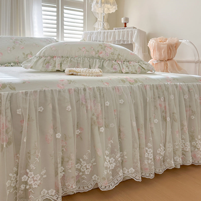 Sage Rose Garden bed skirt with matching pillows on a bed in a softly lit bedroom.