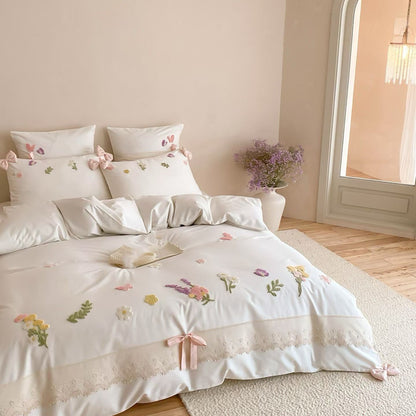 Romantic white floral embroidered bedding set with textured flowers, lace edge, and soft cottage-inspired styling