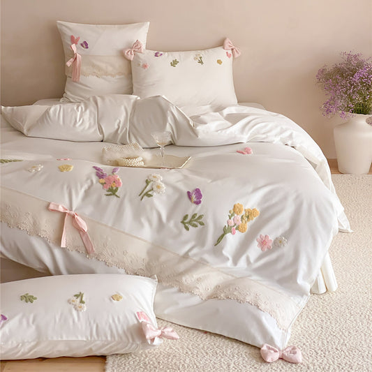 Ivory white long-staple cotton bedding set styled with raised floral embroidery, butterfly details, lace edging, and soft bedroom decor