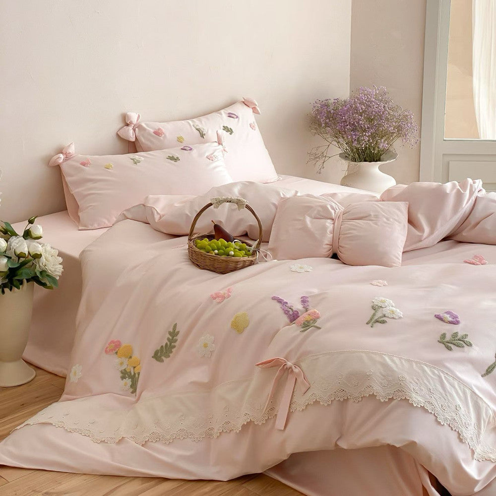 Blush pink long-staple cotton bedding set with floral embroidery, butterfly details, lace edging, and cottage-inspired decor