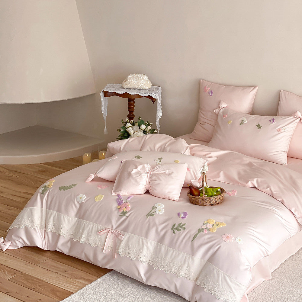 Soft pink embroidered bedding set with textured flowers, delicate lace trim, and romantic coquette bedroom styling