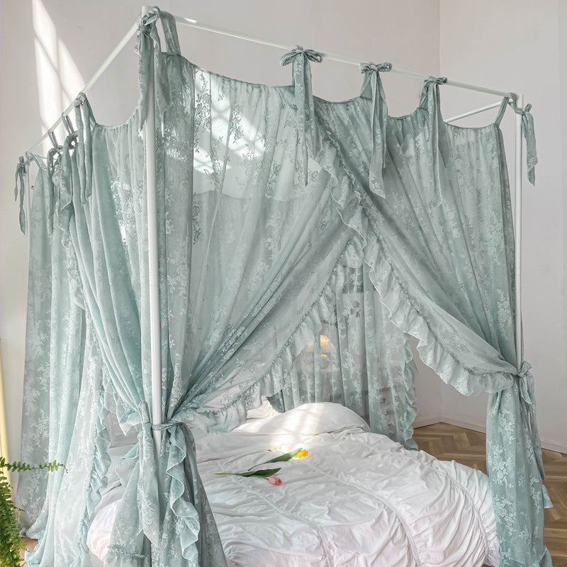 A teal floral lace bed canopy with ruffle trim, tied back at the corners, creating a dreamy and elegant look. The canopy is on a white 4-poster bed frame with white bedding.