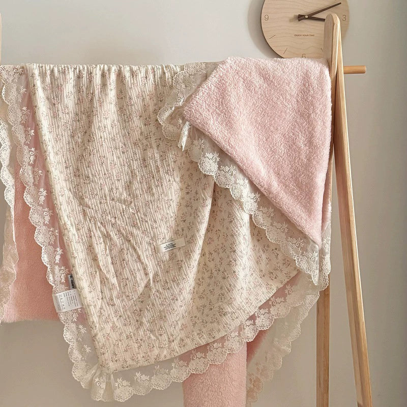 Pink floral cotton gauze comforter hanging on a wooden rack, displaying full size and pink plush fleece reverse side.