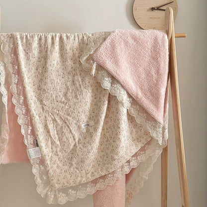 Pink floral cotton gauze comforter hanging on a wooden rack, displaying full size and pink plush fleece reverse side.