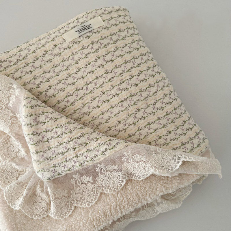 Muslin cotton baby blanket featuring purple and green vine bow pattern, with cozy cream fleece backing and lace trim.