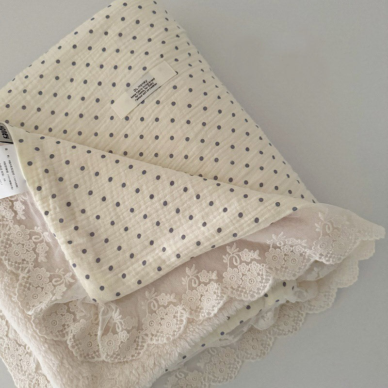 Polka dot cotton gauze blanket in beige and grey, featuring soft fleece interior and elegant lace trim.