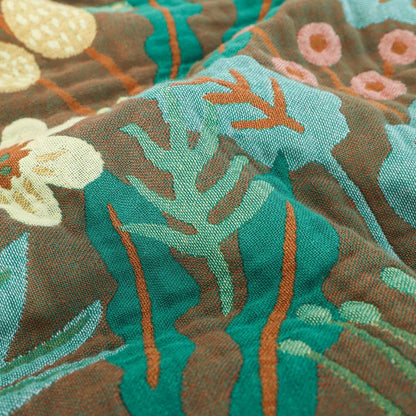 Close-up of tropical leaf jacquard texture on throw blanket