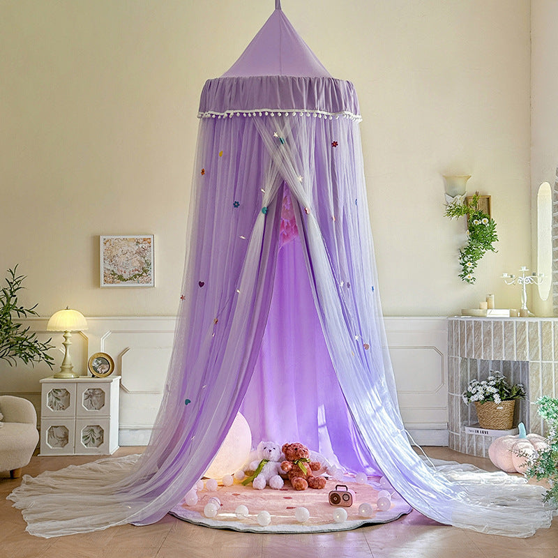 Lavender Purple double-layer kids canopy tent with pom-pom trim, set up as a dreamy play area over a round rug with a moon lamp and stuffed animals inside.
