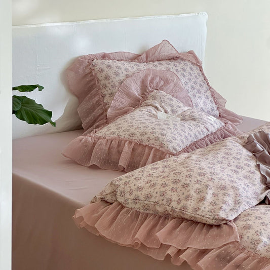 Stacked Lavender Floral Pillow Shams with wide, dotted chiffon ruffled edges, resting on the solid mauve fitted sheet, clearly showing the soft texture and color combination.