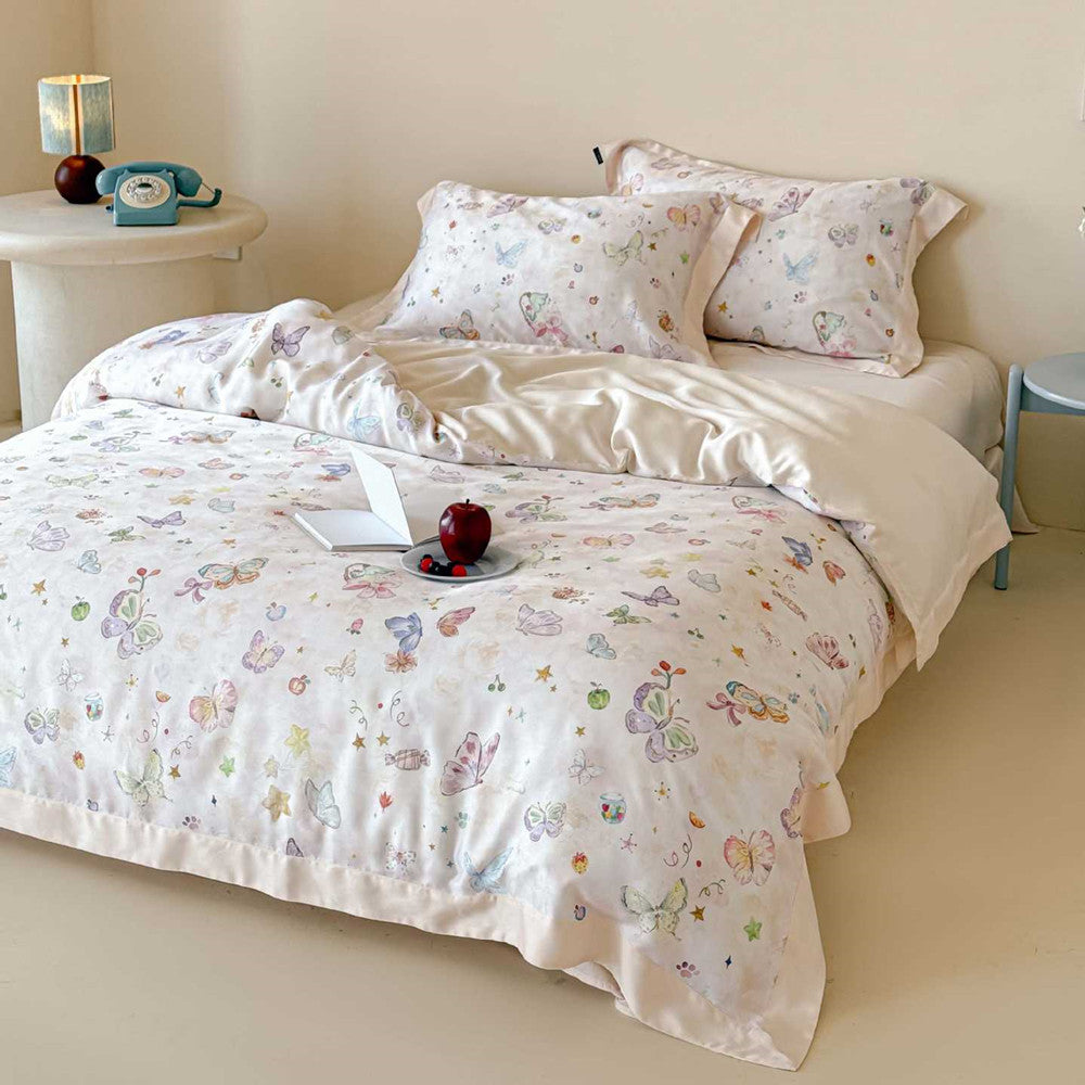 Close-up of the champagne-colored Lyocell bedding set by Winifred Home, showing the vibrant butterfly, star, and fruit watercolor pattern on a soft, breathable fabric base.