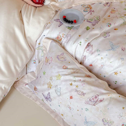 Detail shot of the champagne Lyocell bedding, focusing on the refined butterfly pattern and silky drape of the duvet cover, accented by a small plate of berries on the bed surface.