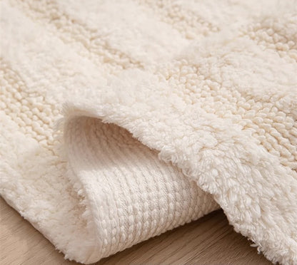 Close-up of the handmade cotton tassel runner rug, showing the textured pile on the top surface and the woven backing on the underside as it is slightly folded.