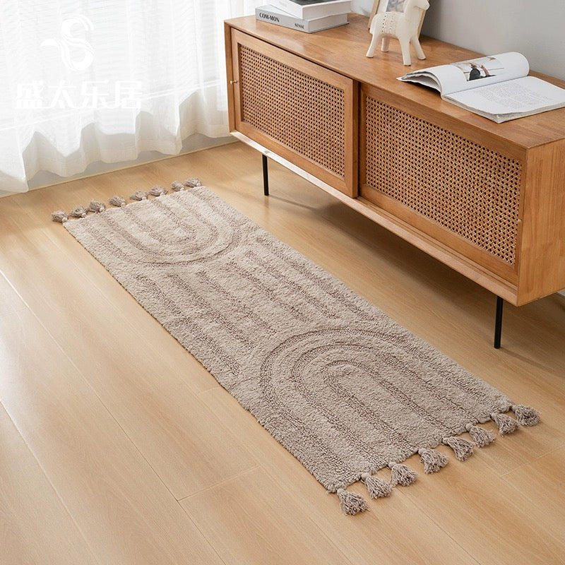 Minimalist rainbow handmade cotton tassel runner rug in light brown color, styled in a minimalist home decor setting.