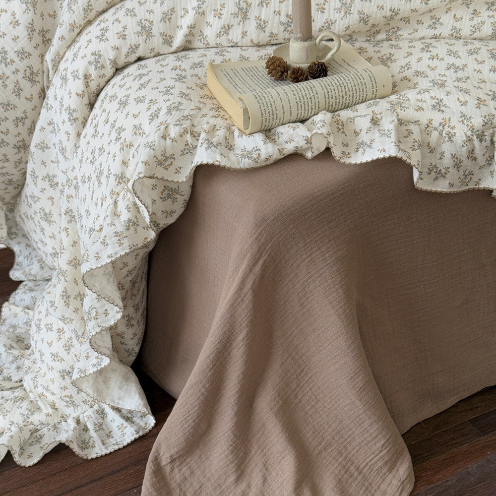 A side close-up showing the osmanthus floral print duvet cover paired with a solid mocha flat sheet, highlighting the ruffled edges and natural crinkle texture