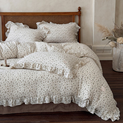A full view of the osmanthus floral print bedding set, including the duvet cover, pillowcases, and flat sheet, on a wooden bed frame, creating a romantic and elegant bedroom atmosphere