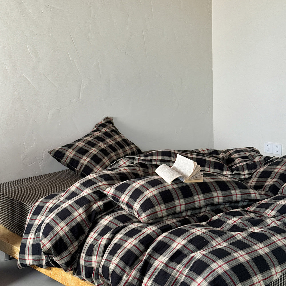 Plaid bedding set on a bed against a plain wall