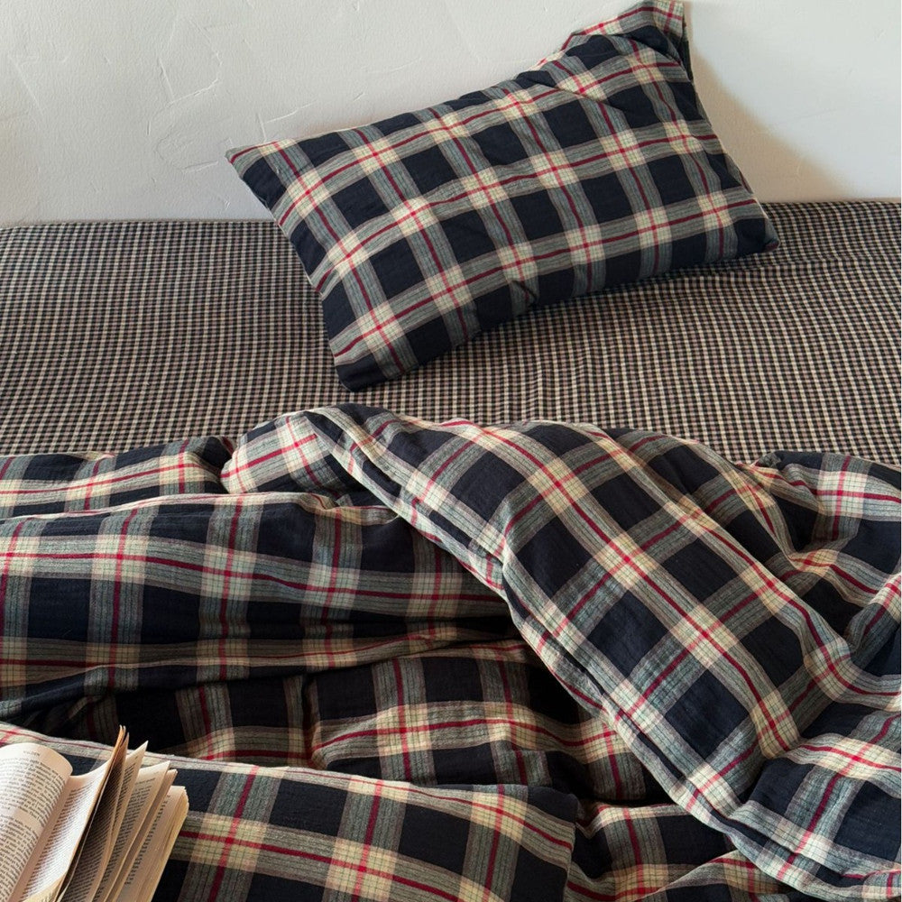 Plaid bedding set with a pillow on a bed