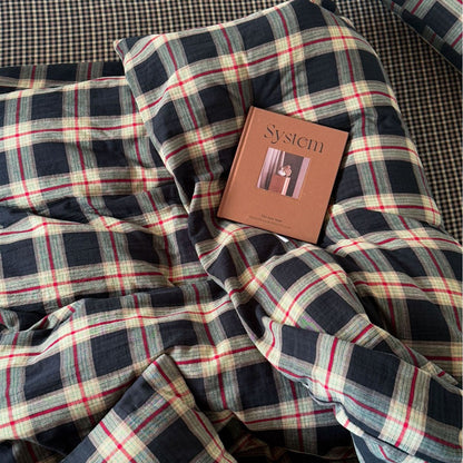Plaid fabric with a book titled 'System' on top, on a checkered background