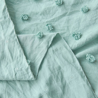 Close-up of sage green polyester canopy fabric with pom pom texture and edge detail