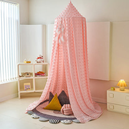 Pink canopy over a child's play area in a room with a shelf and lamp.