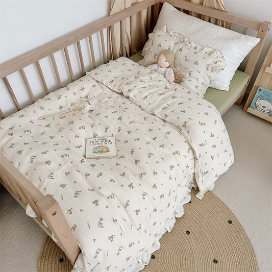 Bunny ruffle toddler bedding set in cotton muslin with duvet cover, pillowcase, and flat sheet on a kids’ bed