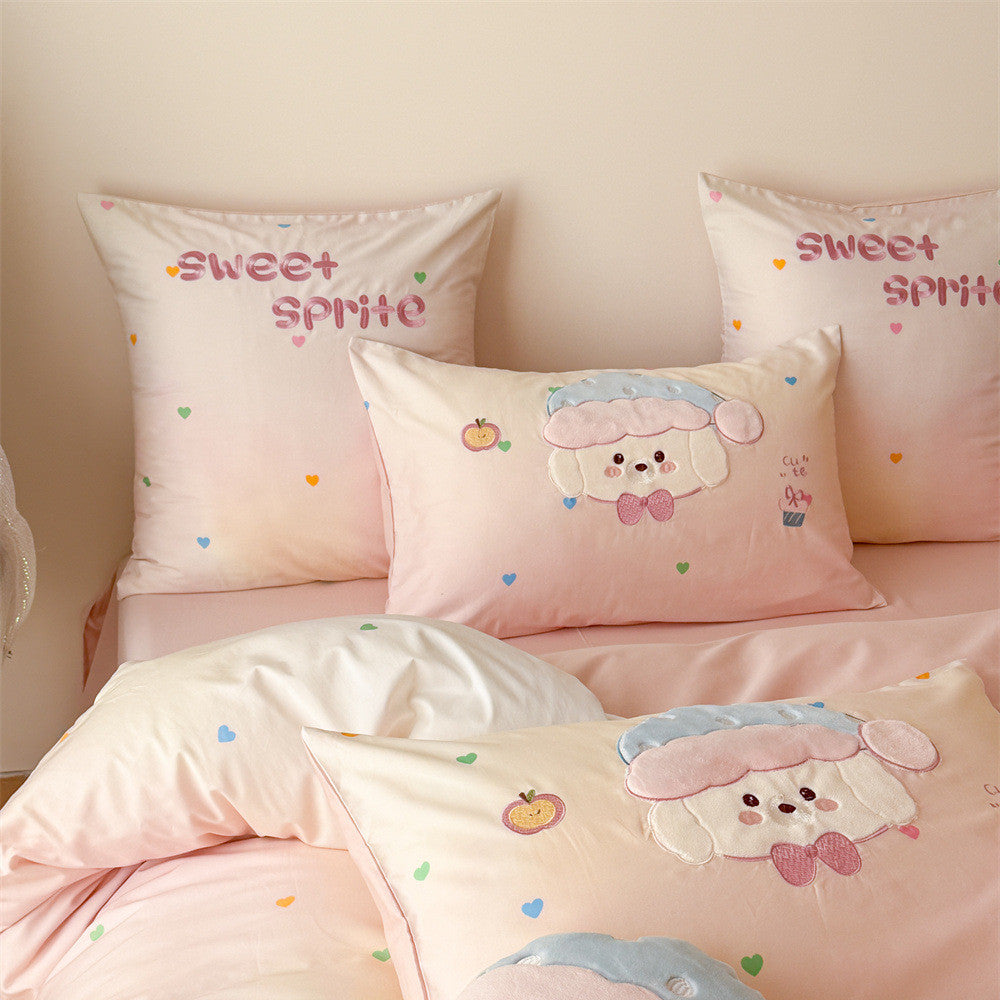 Close-up of blush pink puppy bedding with appliqué dog pillowcases, sweet sprite embroidery, and colorful heart accents