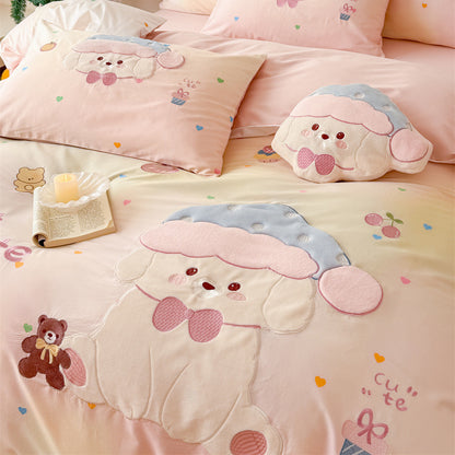 Angled close-up of blush pink puppy bedding set with appliqué dog detail, pastel gradient fabric, and embroidered fruit and heart accents