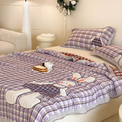 Purple bunny cotton muslin comforter shown from an angled view with plaid edging and pillowcases