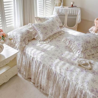 Romantic Garden Bed Skirt in Lavender Meadow with ruffled lace trim and matching floral pillows.