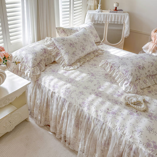 Romantic Garden Bed Skirt in Lavender Meadow with ruffled lace trim and matching floral pillows.
