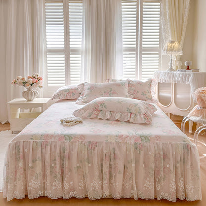 Symmetrical front view of a bed styled with the Vintage Blush bed skirt and coordinating ruffled floral pillowcases.