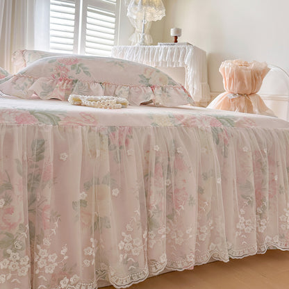 Low-angle shot of the Romantic Garden Bed Skirt in Vintage Blush, showcasing the scalloped floral lace overlay.