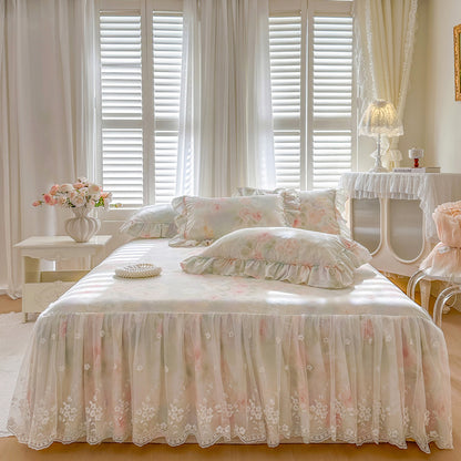 Full view of the sunlit Sage Rose Garden bed skirt featuring an ornate lace overlay in a classic cottage-style bedroom.