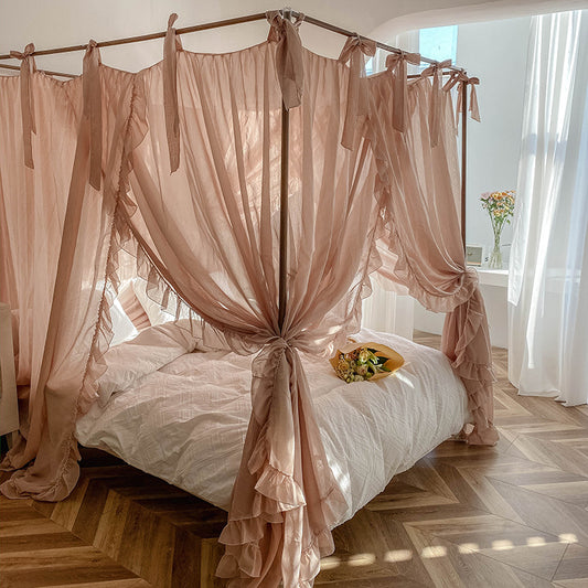 A romantic light coffee lace bed canopy with large ruffles, tied back on a 4-poster bed. The fabric drapes elegantly, creating a cozy and airy bedroom atmosphere.