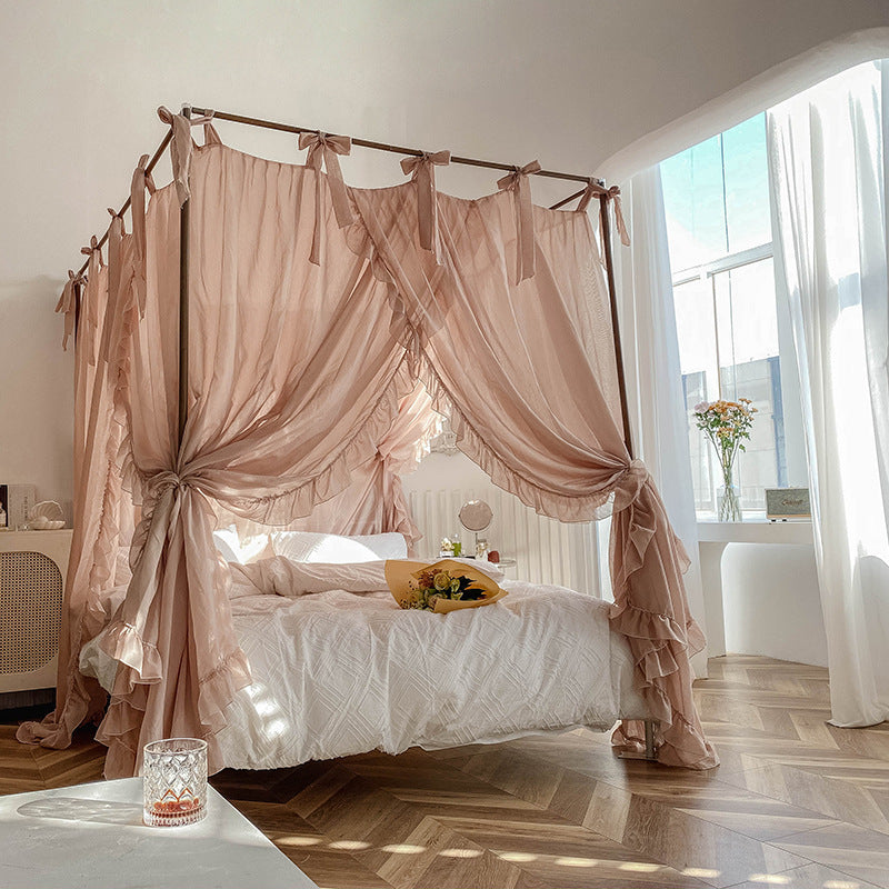 Full shot of a light coffee lace bed canopy on a 4-poster bed, tied back at the corners to reveal a bright and stylish bedroom with rustic decor.